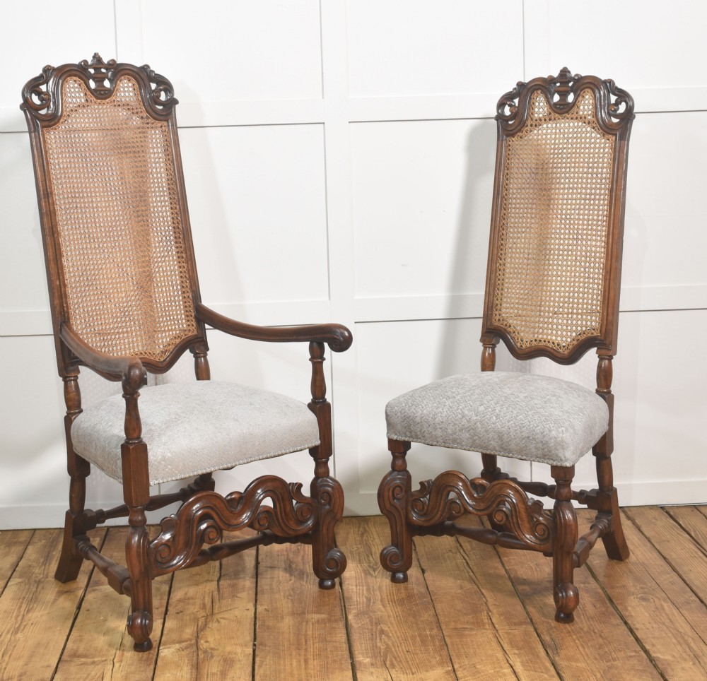 A set of eight walnut dining chairs featuring tall carved frames, woven cane back panels, grey upholstered seats, and scrollwork stretchers. View IX