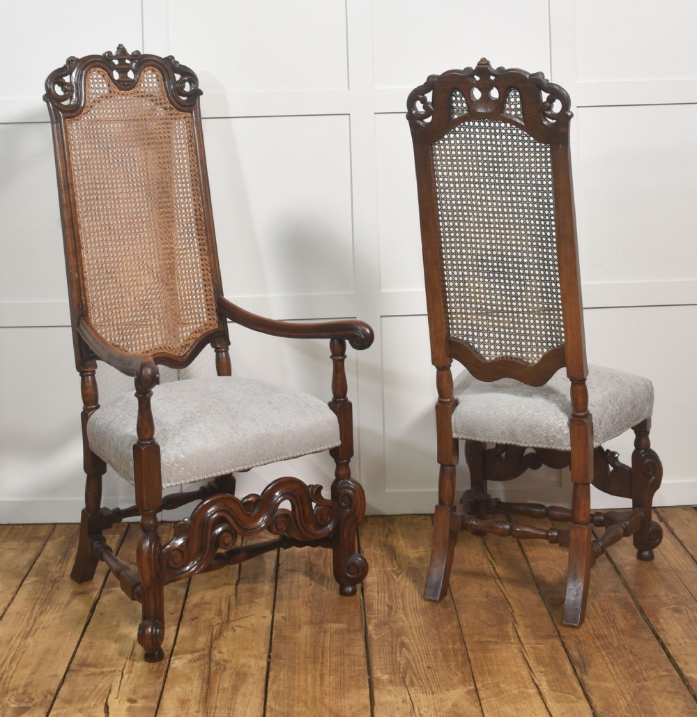 A set of eight walnut dining chairs featuring tall carved frames, woven cane back panels, grey upholstered seats, and scrollwork stretchers. View XII