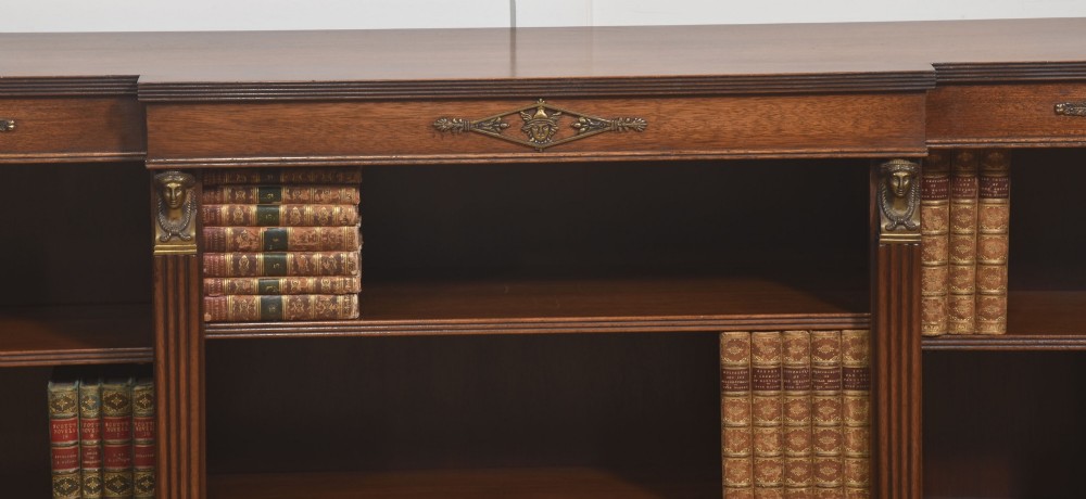 A low Regency style mahogany breakfront open bookcase featuring fluted pilasters, brass mounts, and adjustable shelves. View VI