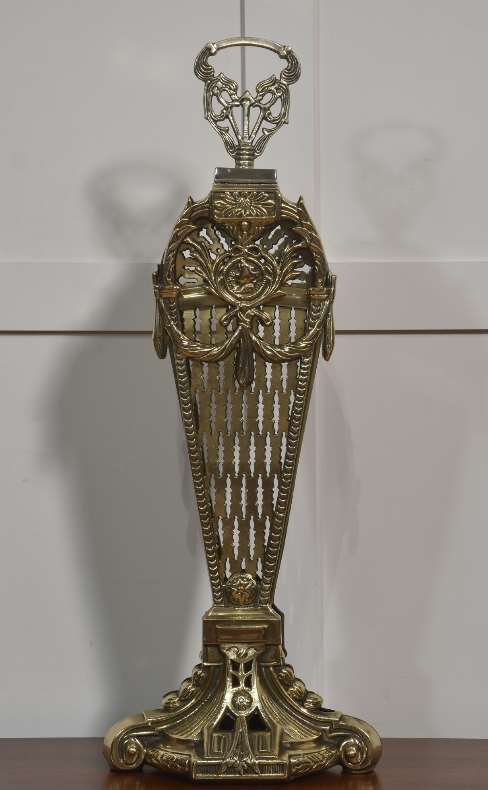 A Victorian brass peacock fire screen with pierced filigree fan blades expanding from a cast metal pedestal base. View III