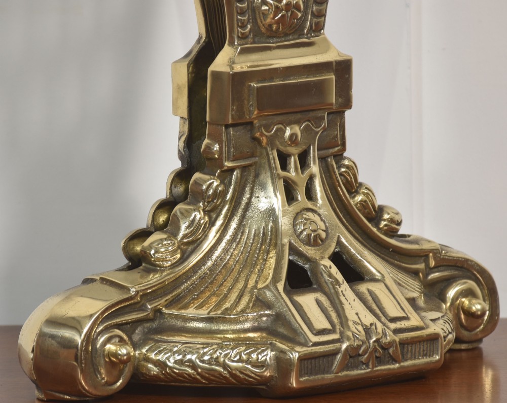 A Victorian brass peacock fire screen with pierced filigree fan blades expanding from a cast metal pedestal base. View VI