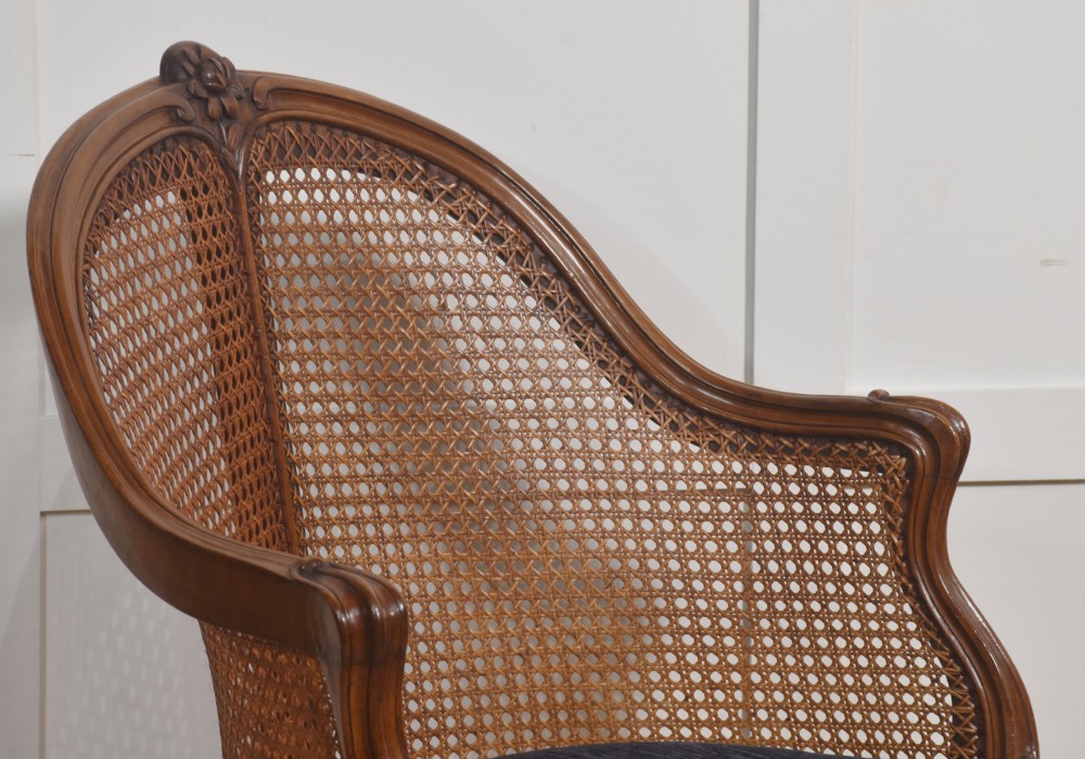 A 19th-century French Louis XV style carved walnut corner tub chair with a woven cane backrest and curved cabriole legs. View II