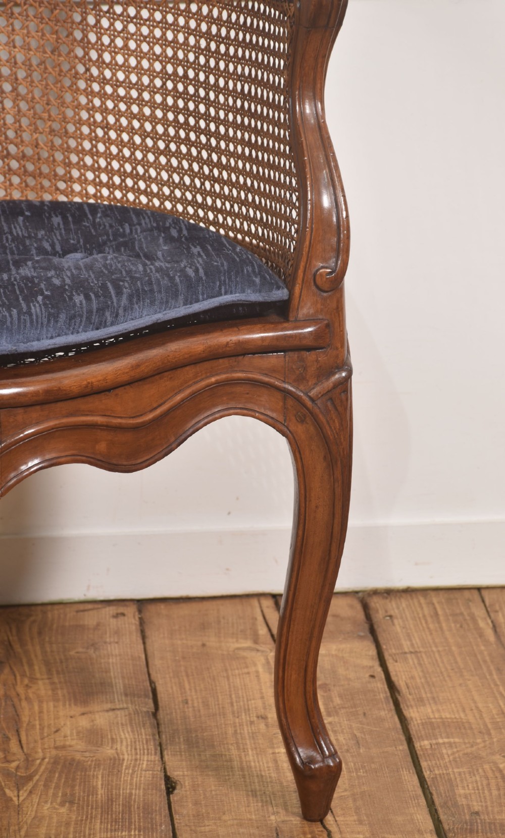 A 19th-century French Louis XV style carved walnut corner tub chair with a woven cane backrest and curved cabriole legs. View VI