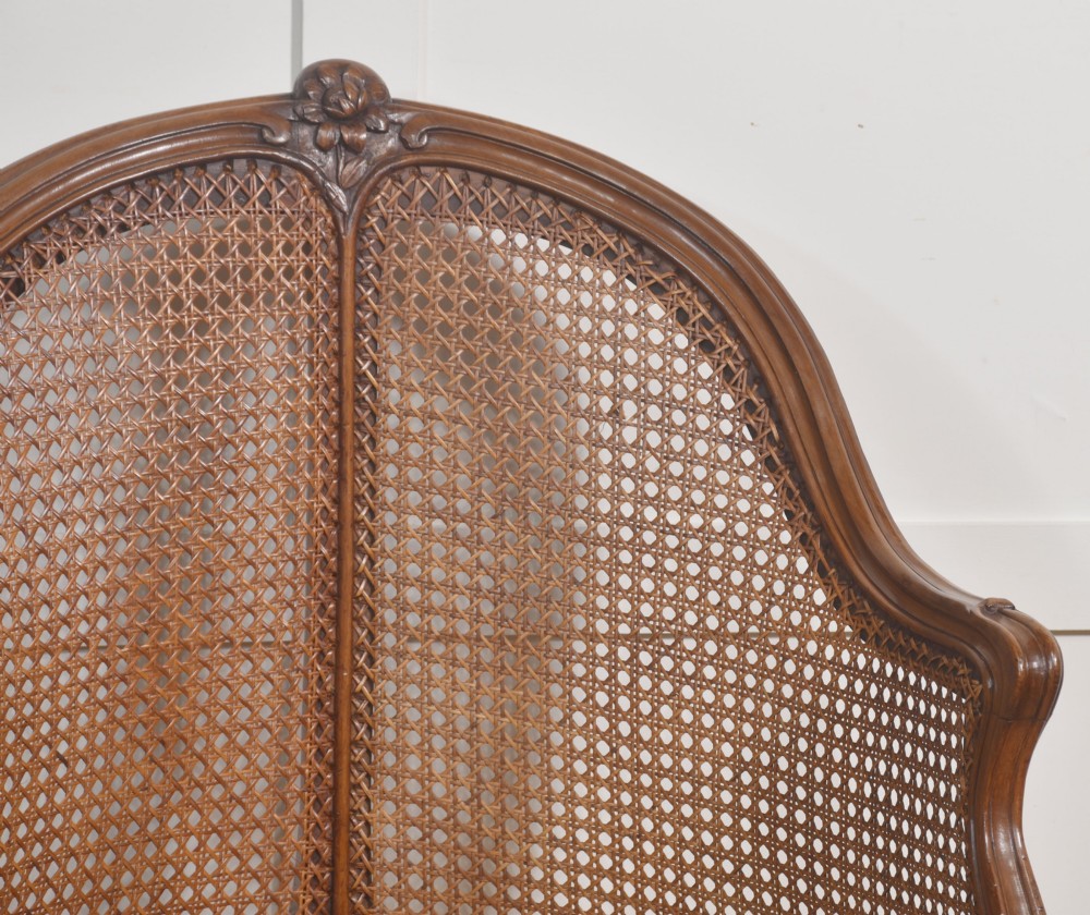 A 19th-century French Louis XV style carved walnut corner tub chair with a woven cane backrest and curved cabriole legs. View VII