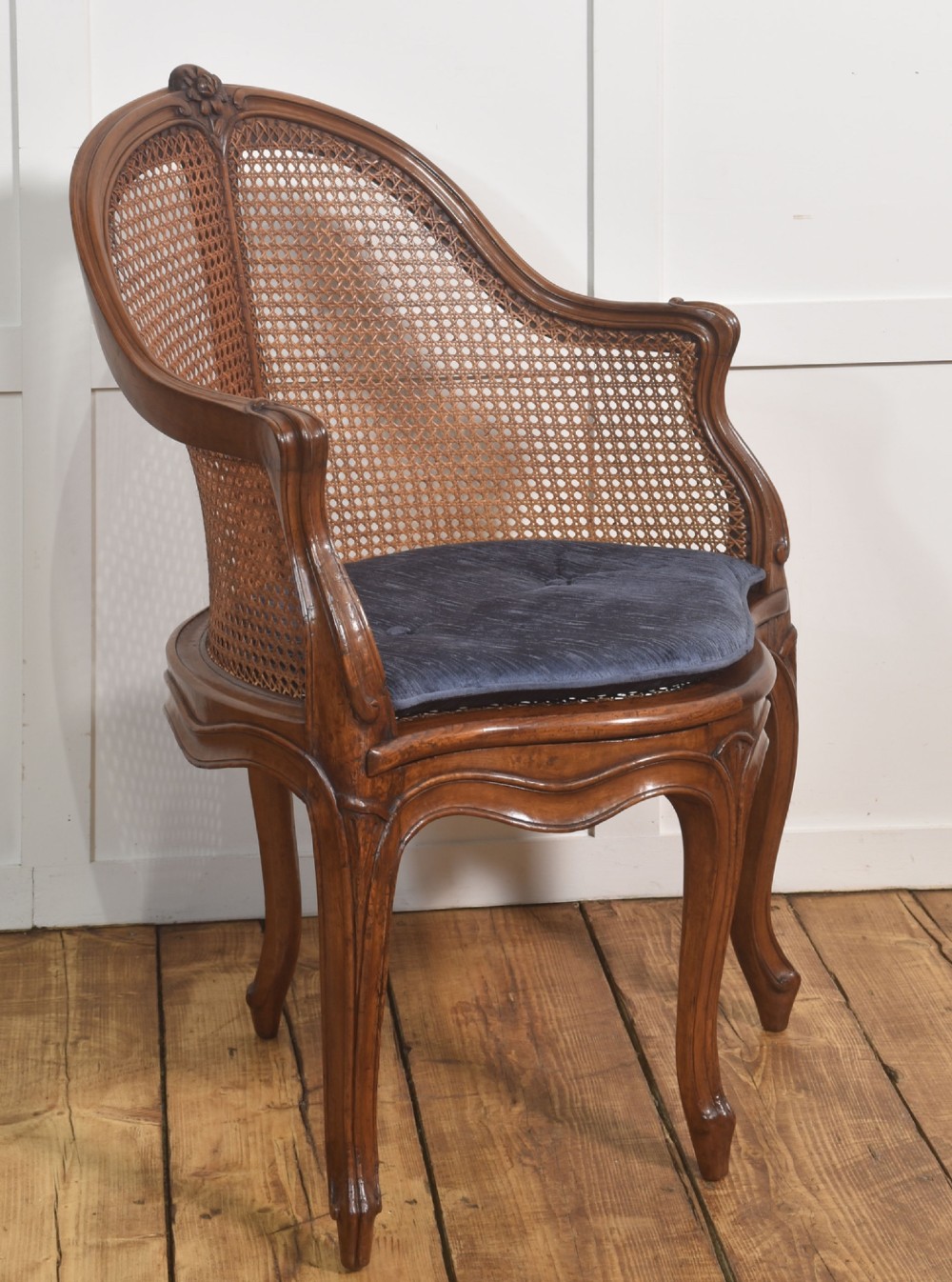A 19th-century French Louis XV style carved walnut corner tub chair with a woven cane backrest and curved cabriole legs. View XI