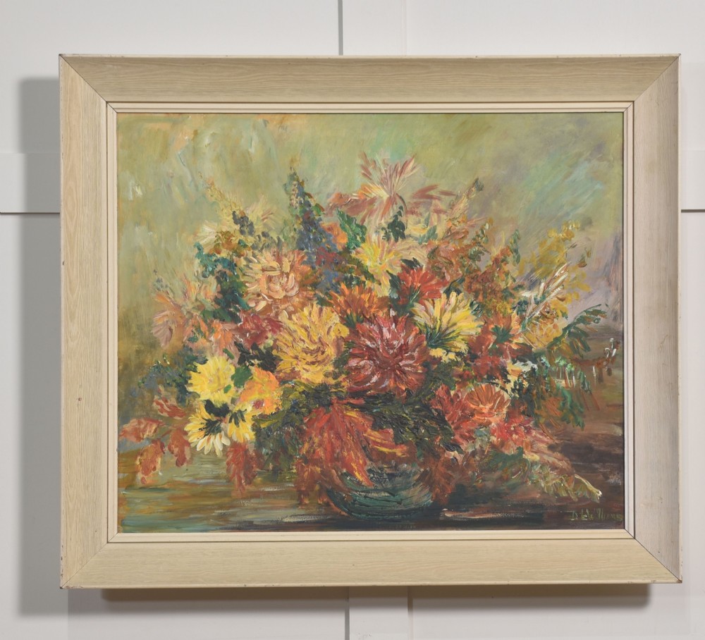 An oil painting depicting a dense arrangement of yellow, red, and orange flowers in a bowl, set within a light cream wooden frame.