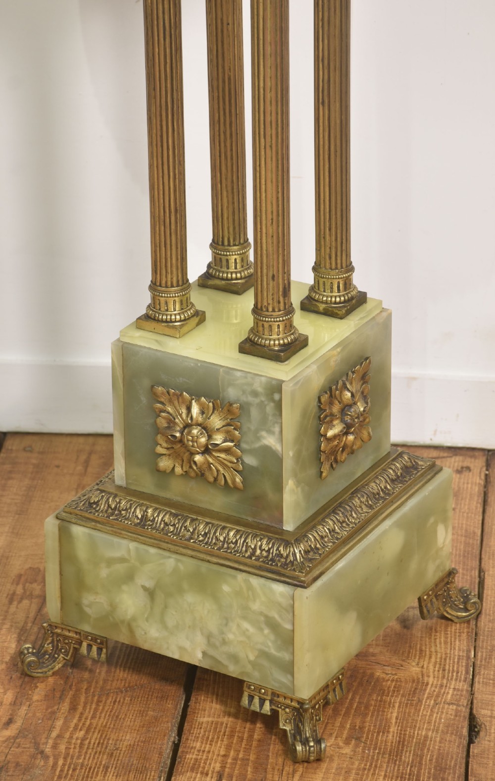 A Neoclassical circular green onyx pedestal table supported by four fluted gilt brass columns on a stepped plinth base. View VI