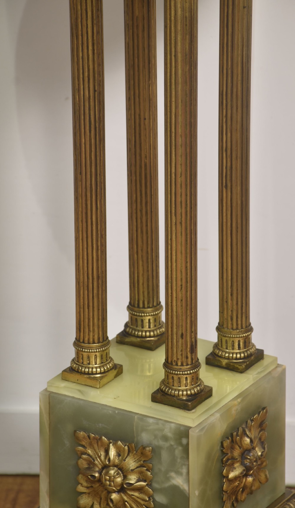 A Neoclassical circular green onyx pedestal table supported by four fluted gilt brass columns on a stepped plinth base. View VII