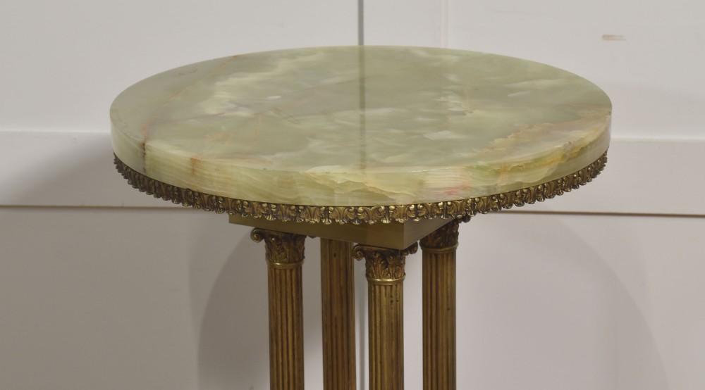 A Neoclassical circular green onyx pedestal table supported by four fluted gilt brass columns on a stepped plinth base. View VIII
