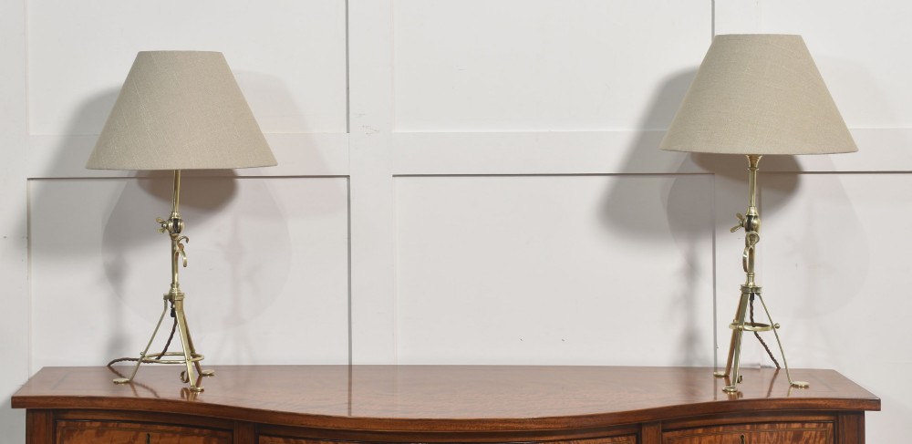 A pair of antique brass adjustable lamps featuring tripod bases with pad feet, central articulated joints with wing nuts, and tilting bulb holders. View III