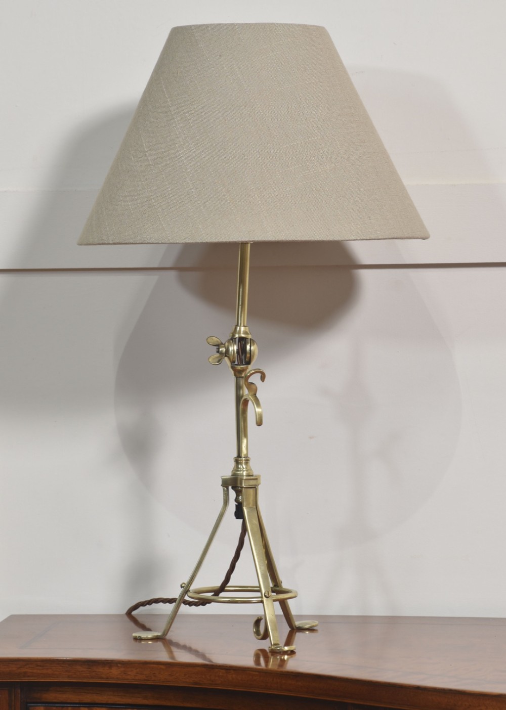 A pair of antique brass adjustable lamps featuring tripod bases with pad feet, central articulated joints with wing nuts, and tilting bulb holders. View IV