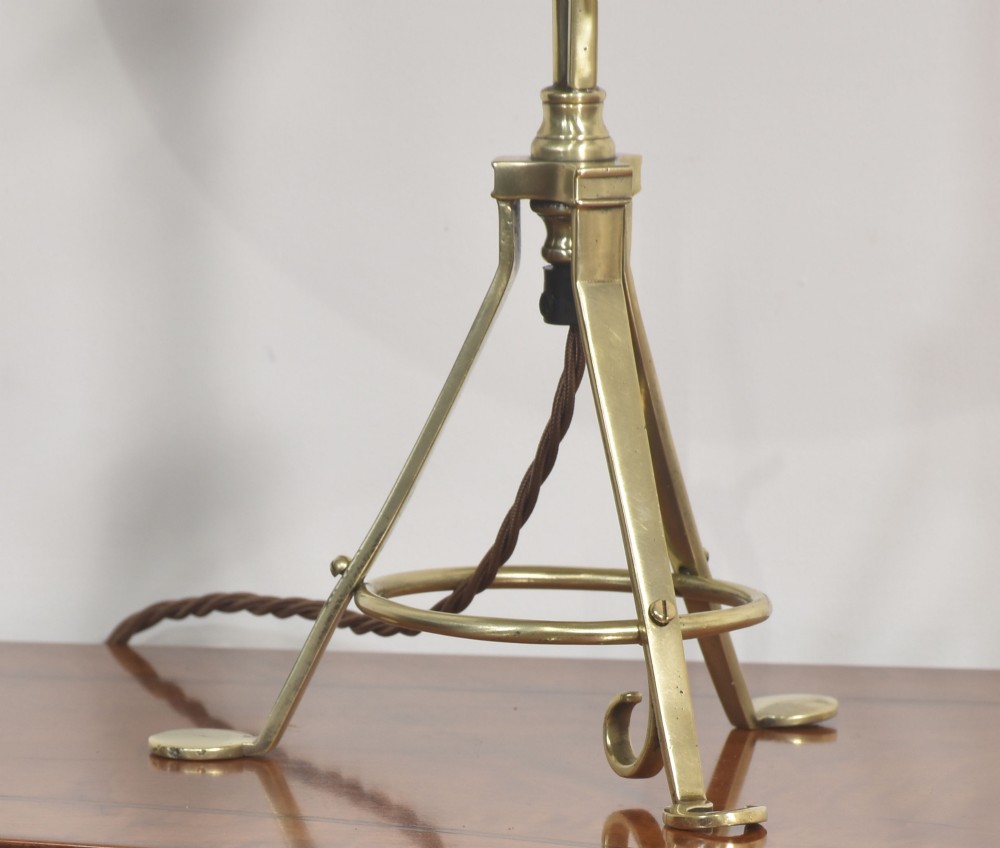 A pair of antique brass adjustable lamps featuring tripod bases with pad feet, central articulated joints with wing nuts, and tilting bulb holders. View V