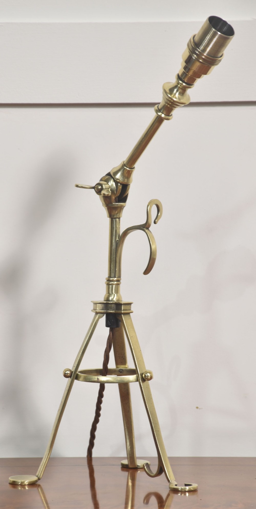 A pair of antique brass adjustable lamps featuring tripod bases with pad feet, central articulated joints with wing nuts, and tilting bulb holders. View IX
