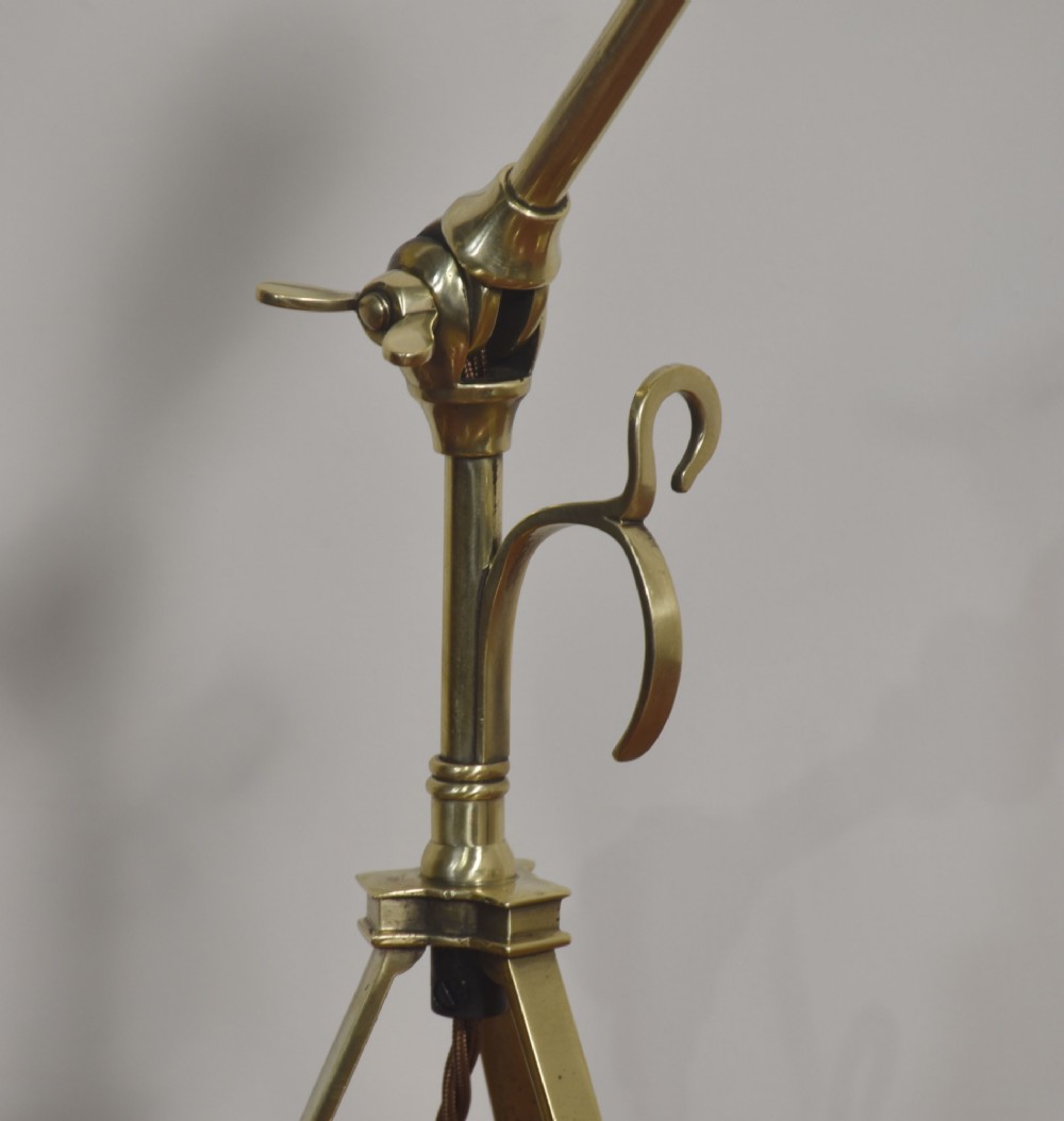 A pair of antique brass adjustable lamps featuring tripod bases with pad feet, central articulated joints with wing nuts, and tilting bulb holders. View XI
