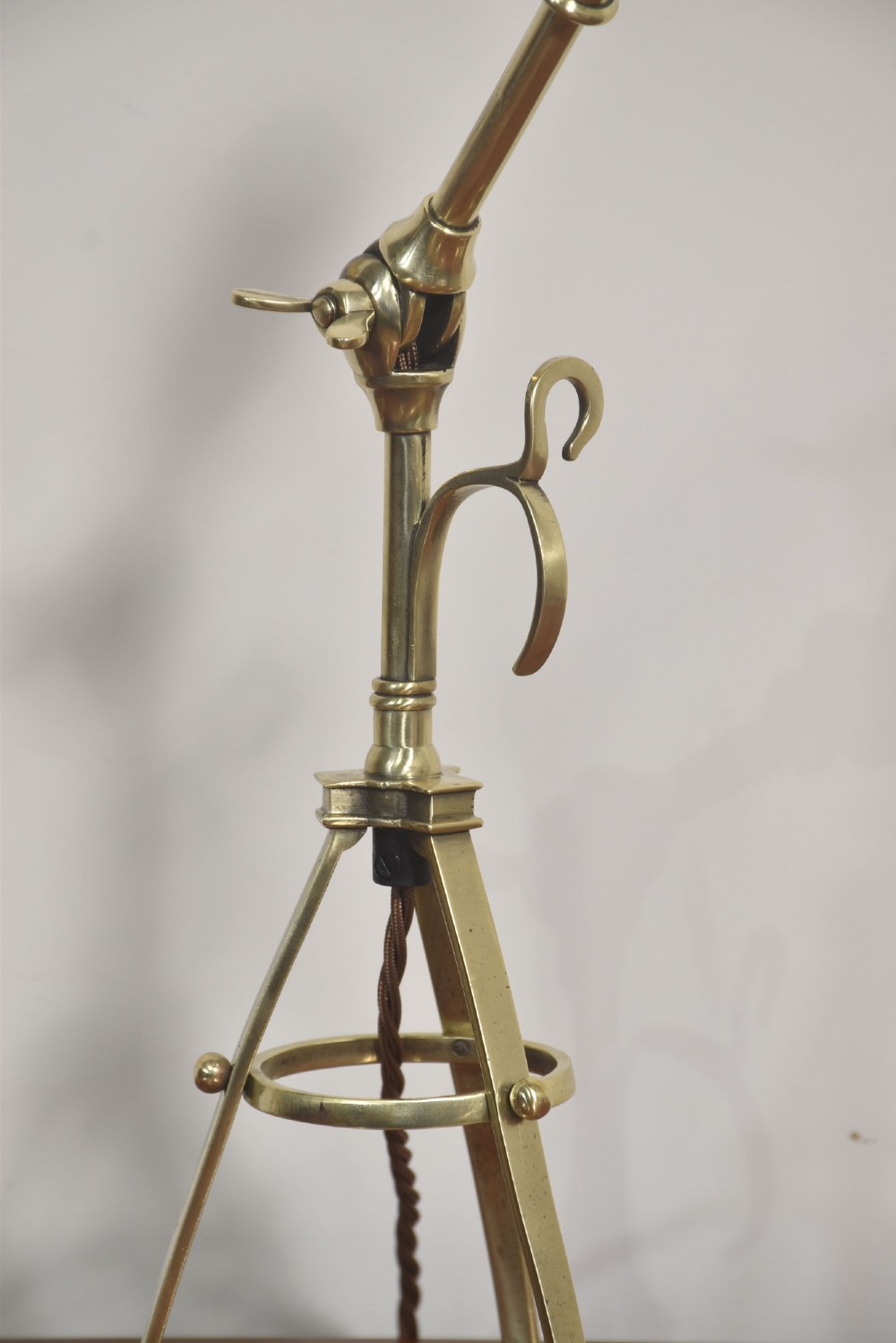A pair of antique brass adjustable lamps featuring tripod bases with pad feet, central articulated joints with wing nuts, and tilting bulb holders. View XII