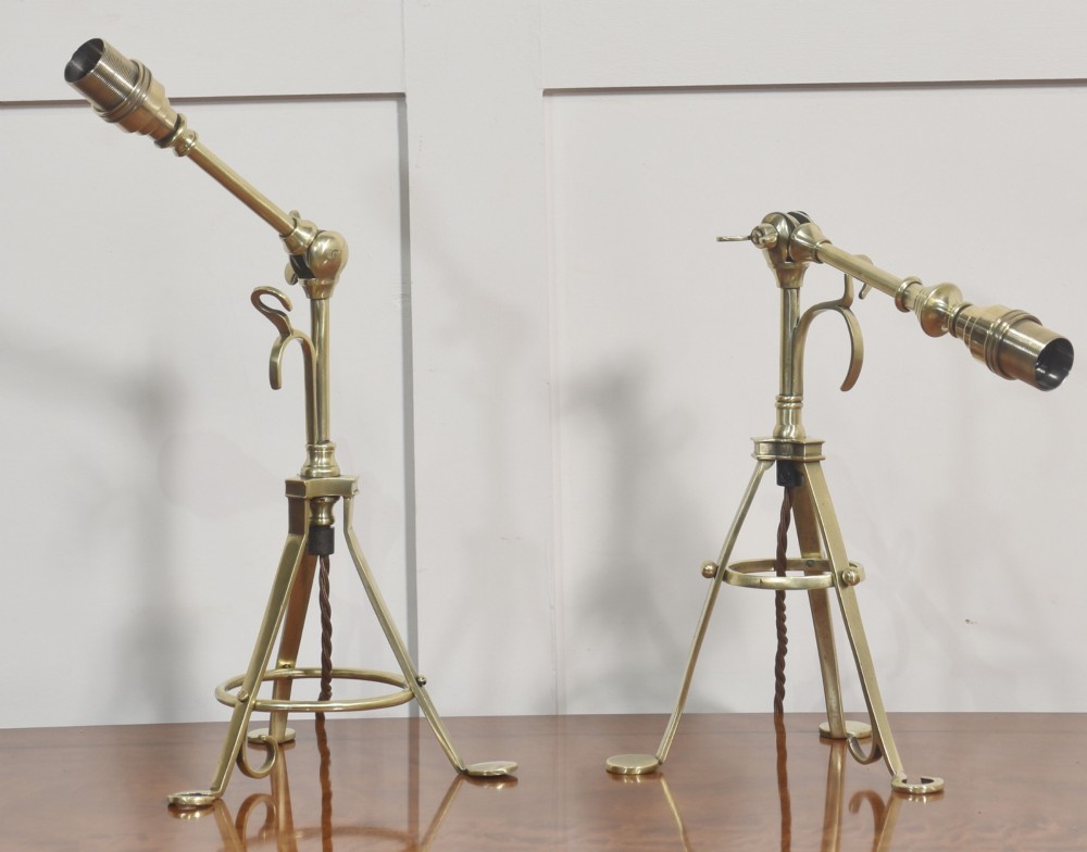 A pair of antique brass adjustable lamps featuring tripod bases with pad feet, central articulated joints with wing nuts, and tilting bulb holders. View XIV