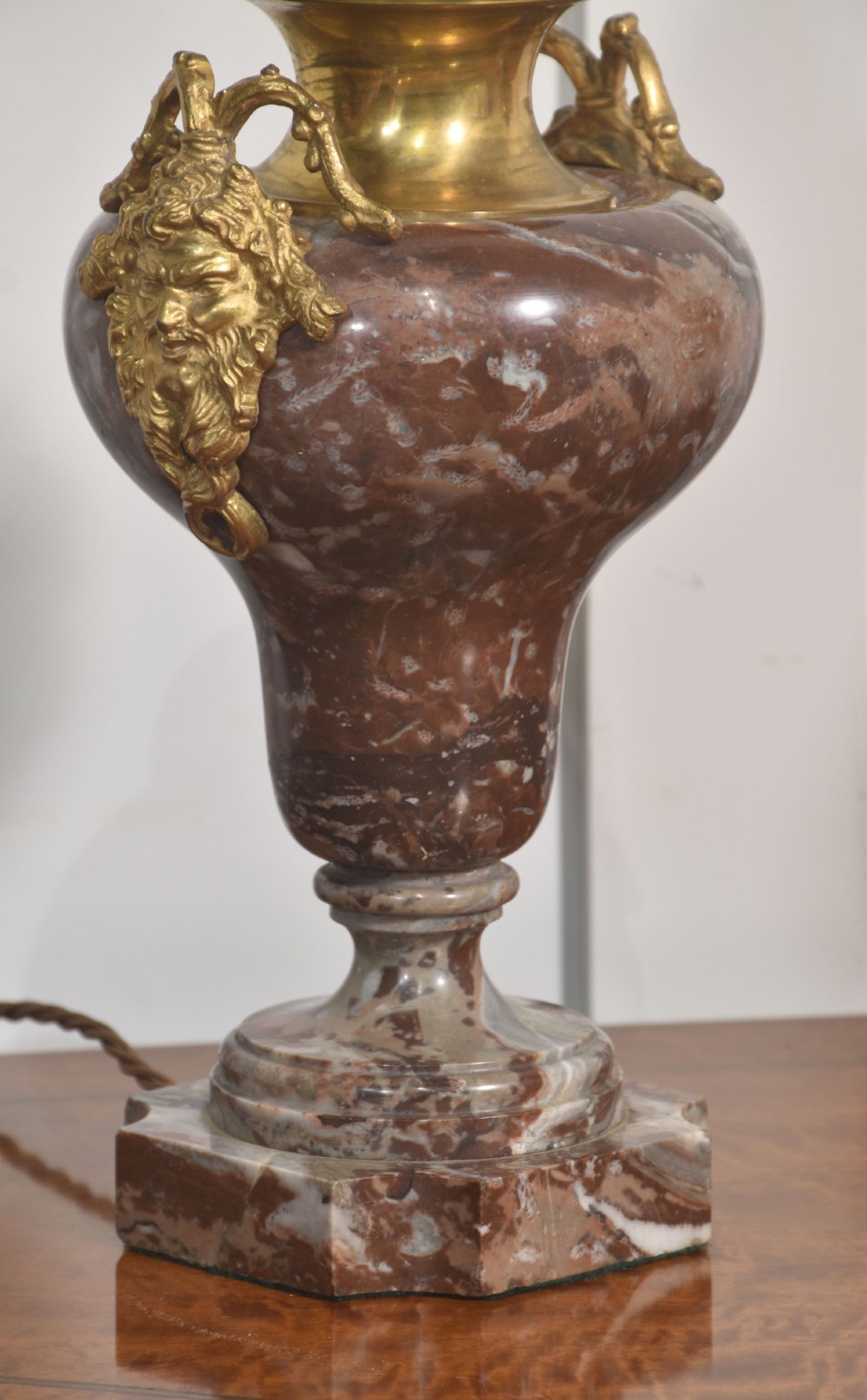 A pair of urn-shaped table lamps crafted from veined red marble with gilt brass collars and decorative side handles. View VII