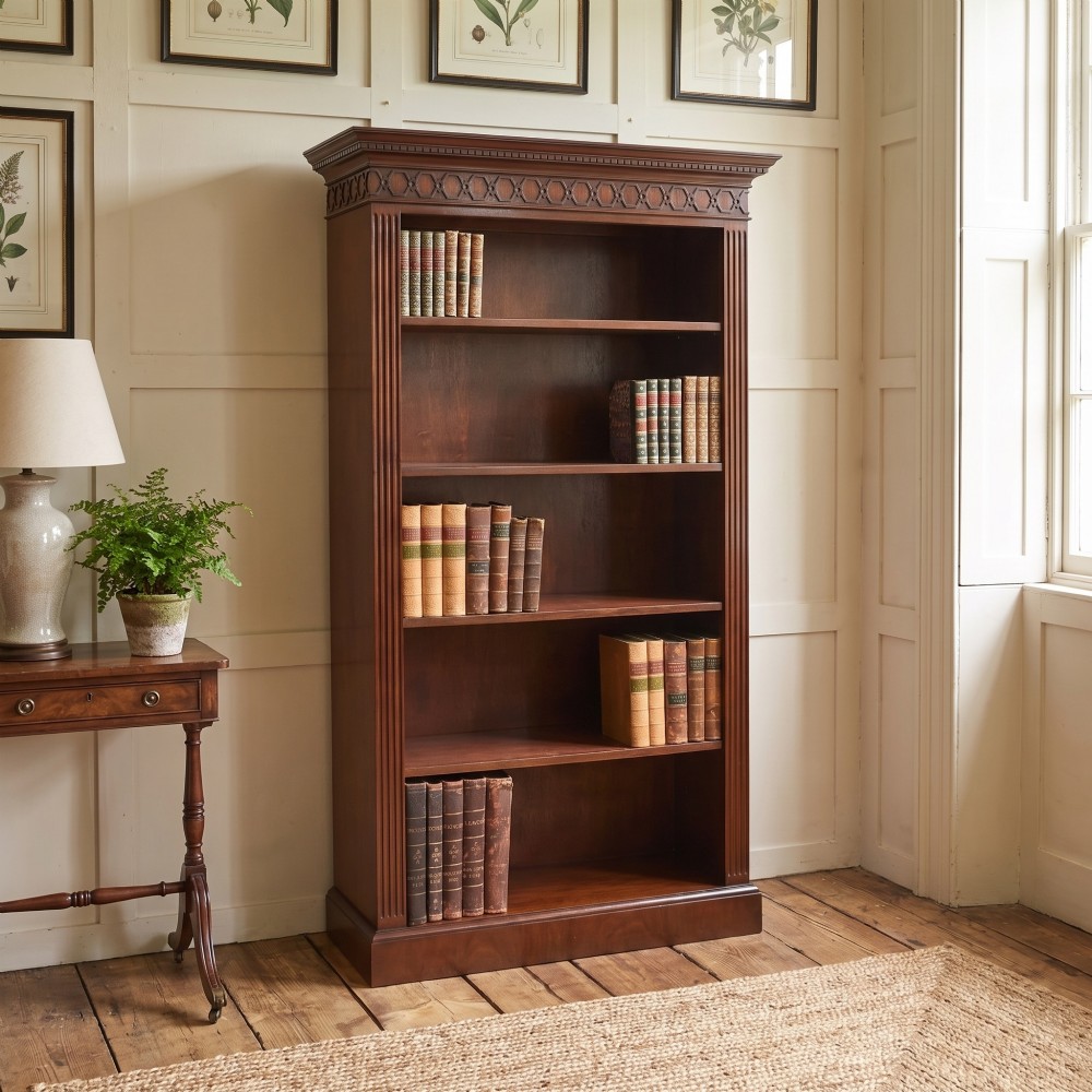 A tall mahogany open bookcase featuring adjustable shelves, fluted side pilasters, and a carved geometric frieze beneath a moulded cornice. View II