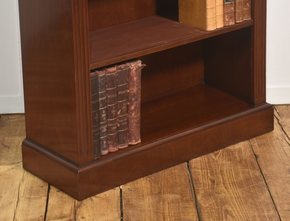 A tall mahogany open bookcase featuring adjustable shelves, fluted side pilasters, and a carved geometric frieze beneath a moulded cornice. View VII