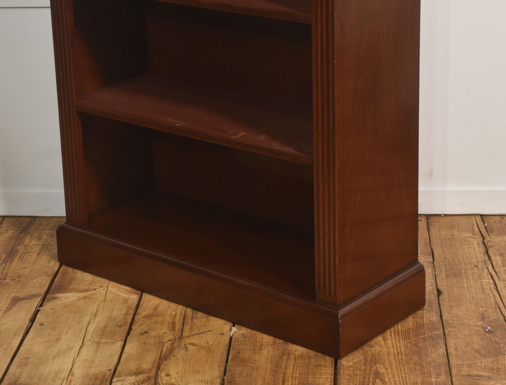 A tall mahogany open bookcase featuring adjustable shelves, fluted side pilasters, and a carved geometric frieze beneath a moulded cornice. View XII