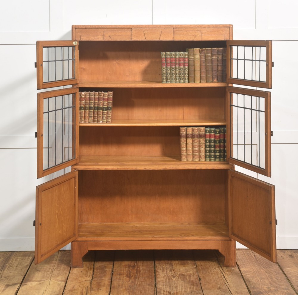 An Art Deco medium oak bookcase featuring two upper sections with leaded glass doors above a double-door base cupboard. View III