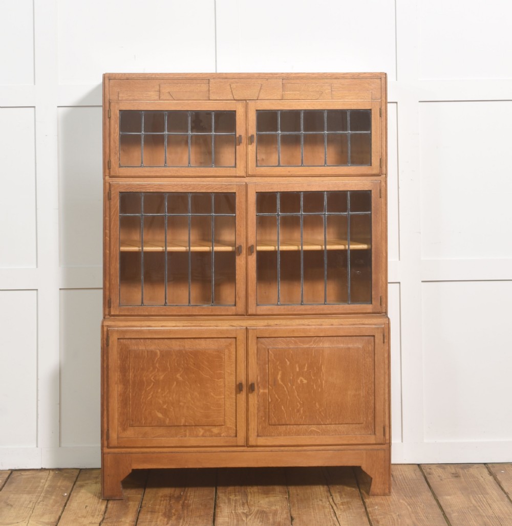 An Art Deco medium oak bookcase featuring two upper sections with leaded glass doors above a double-door base cupboard. View VII