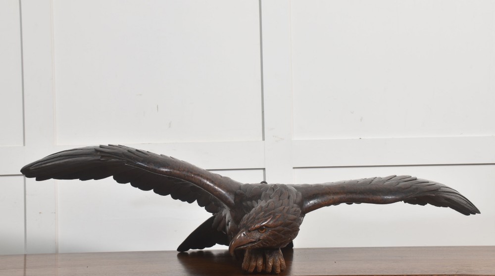 A dark wood eagle sculpture hand-carved in mid-flight with outstretched wings and carved feather detailing. View XII