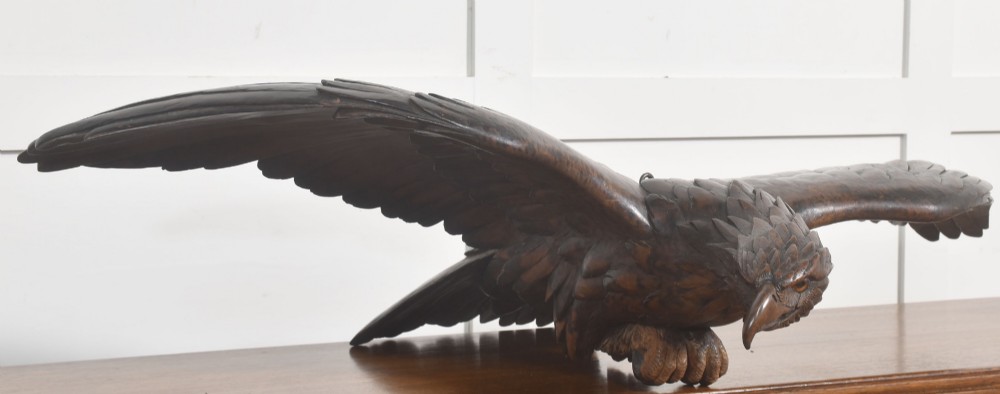 A dark wood eagle sculpture hand-carved in mid-flight with outstretched wings and carved feather detailing. View XIV