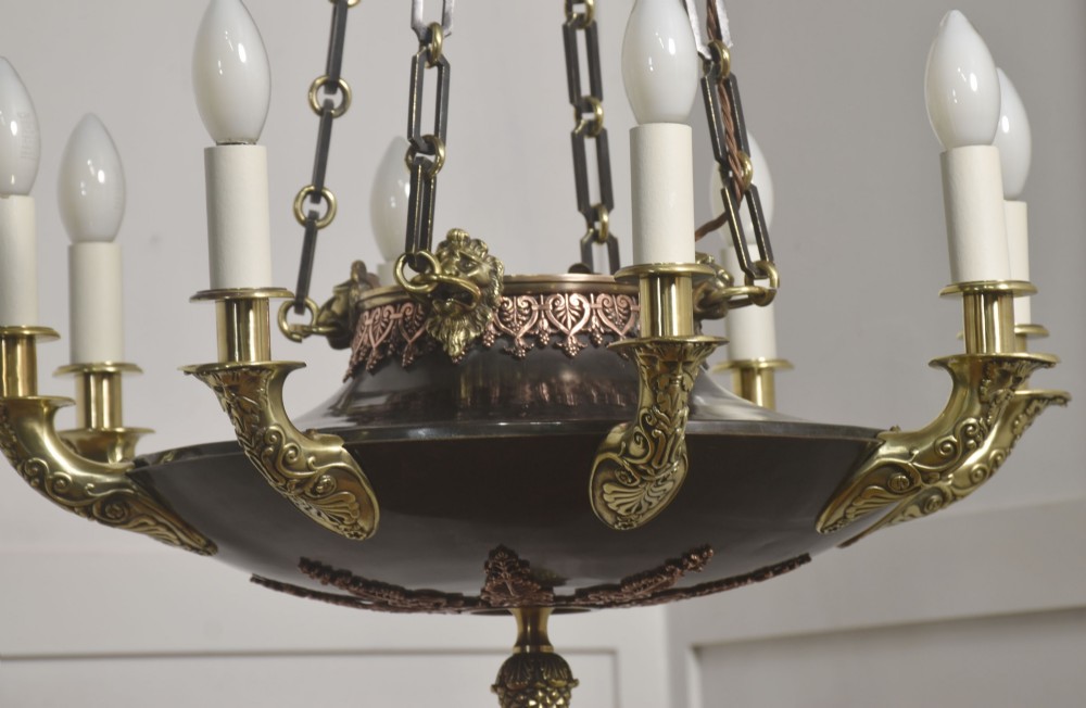 An Empire Revival brass and copper eight-light chandelier featuring a central dish supported by link chains and decorated with cast brass mounts and candle-style lights. View III
