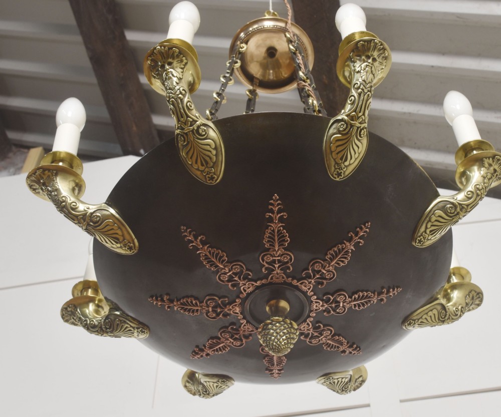 An Empire Revival brass and copper eight-light chandelier featuring a central dish supported by link chains and decorated with cast brass mounts and candle-style lights. View VII