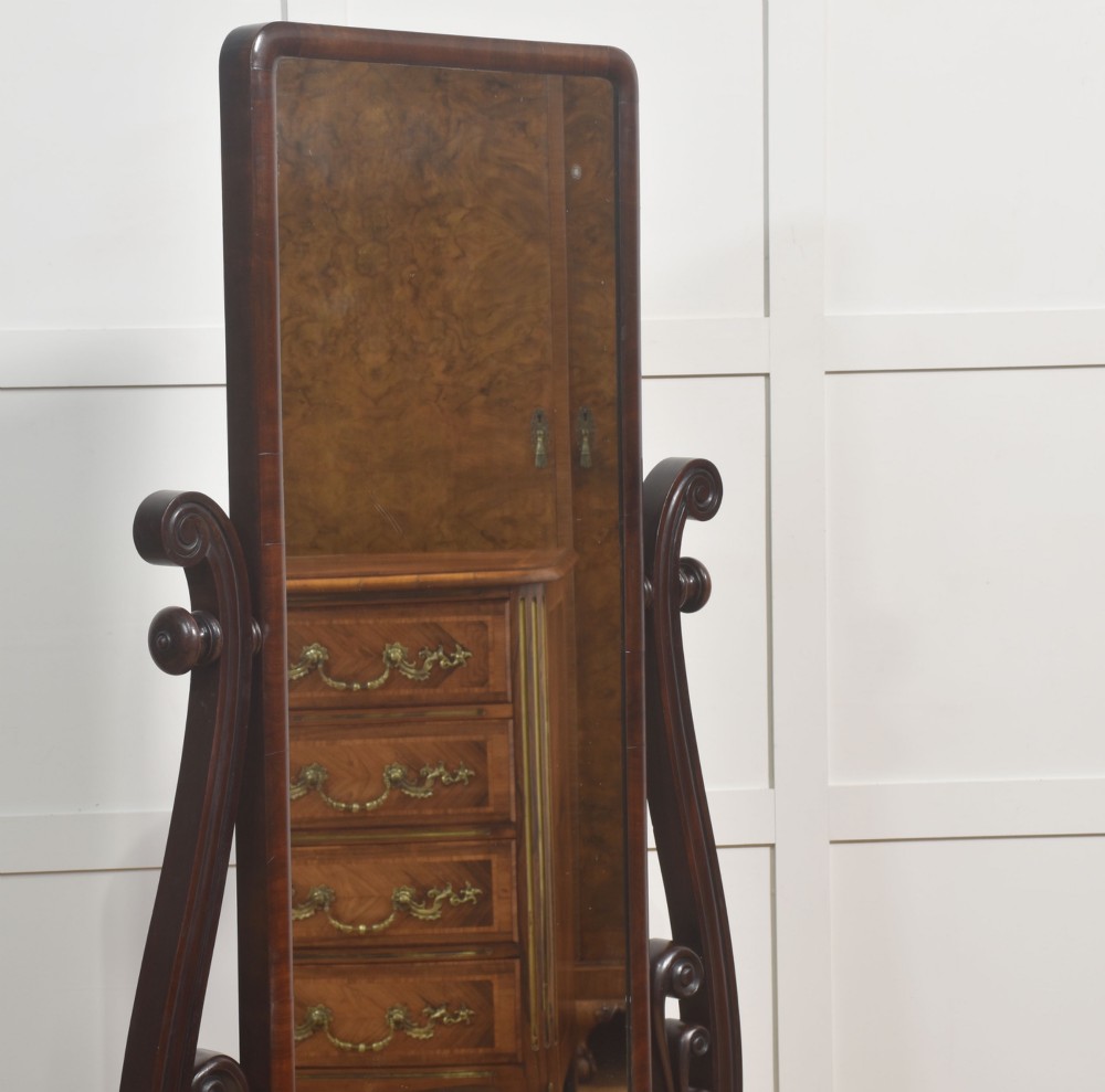 A William IV mahogany cheval mirror featuring carved scroll upright supports, a tilting full-length rectangular glass frame, and a stretcher base with swept feet. View IV