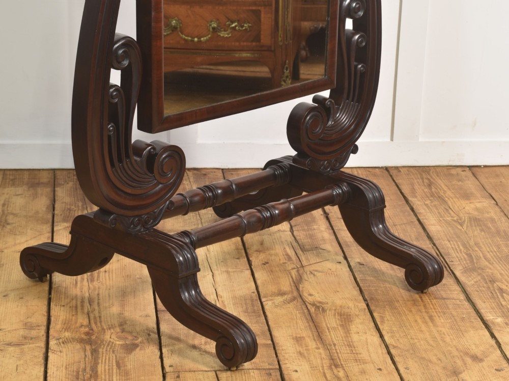 A William IV mahogany cheval mirror featuring carved scroll upright supports, a tilting full-length rectangular glass frame, and a stretcher base with swept feet. View V