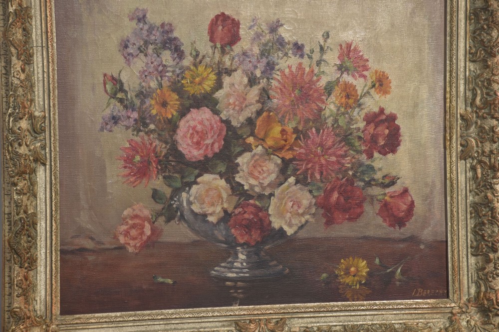 An oil painting on canvas depicting a colourful floral arrangement in a silver urn vase, set within a heavily carved gilt frame. View IV
