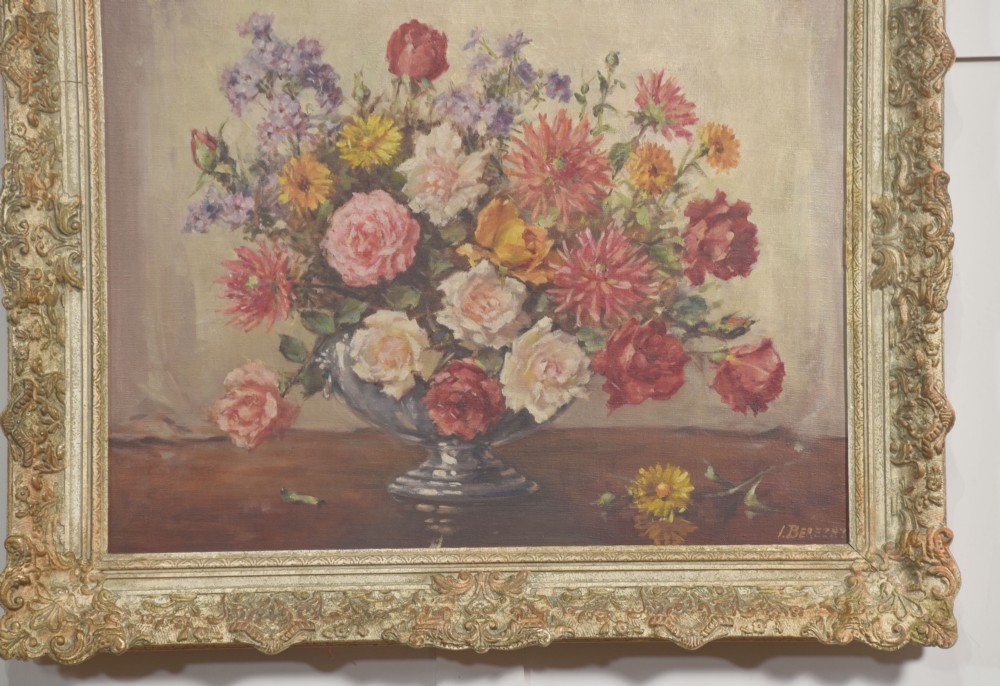 An oil painting on canvas depicting a colourful floral arrangement in a silver urn vase, set within a heavily carved gilt frame. View VI