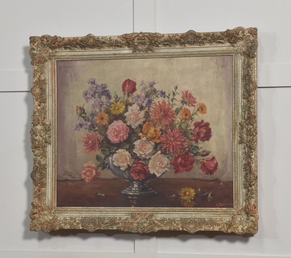 An oil painting on canvas depicting a colourful floral arrangement in a silver urn vase, set within a heavily carved gilt frame. View VII