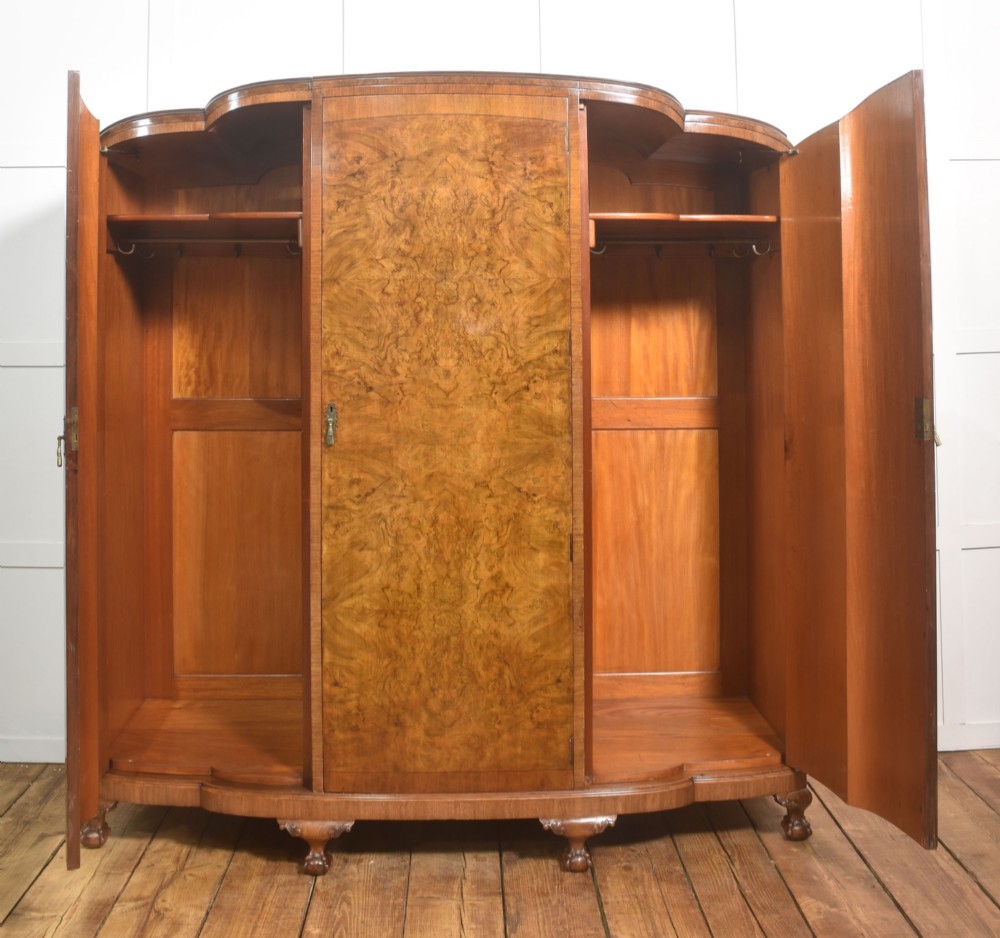 An Art Deco burr walnut breakfront wardrobe with curved side doors, a raised central door, and short carved feet. View III