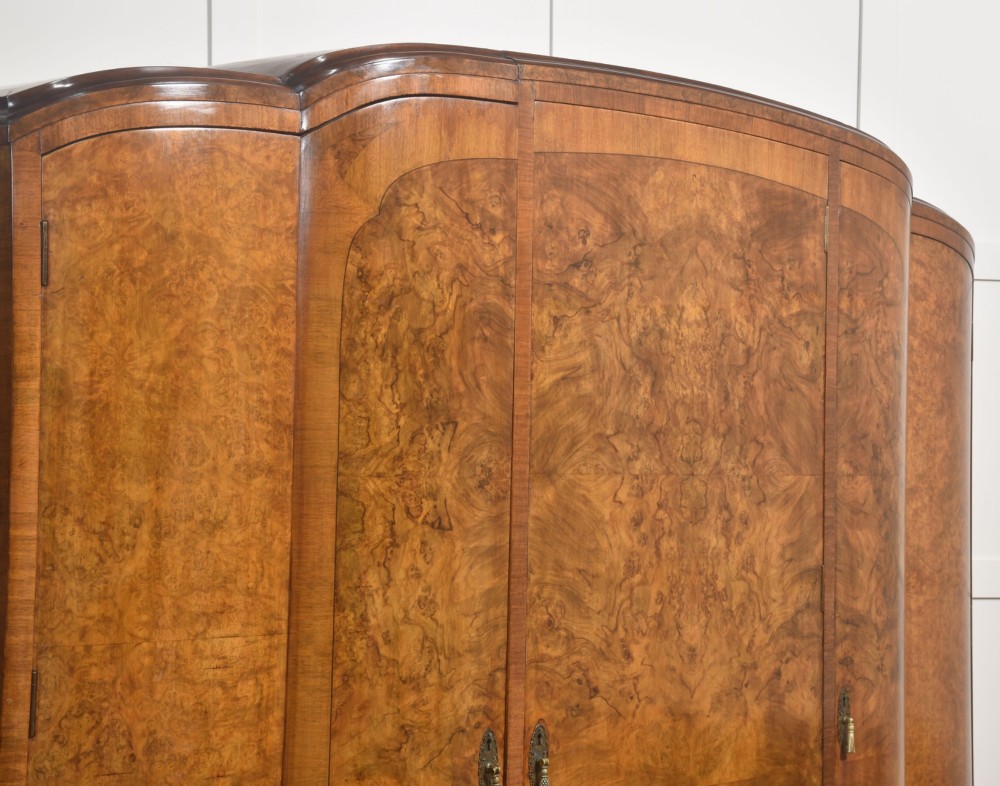 An Art Deco burr walnut breakfront wardrobe with curved side doors, a raised central door, and short carved feet. View VIII
