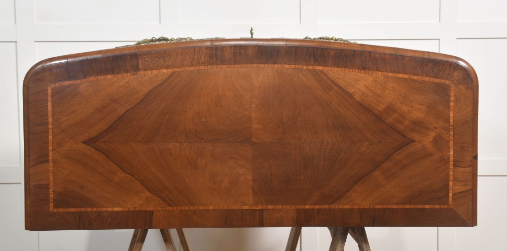 A French Louis XV style serpentine chest of drawers featuring geometric wood marquetry and decorative brass handles. View XII