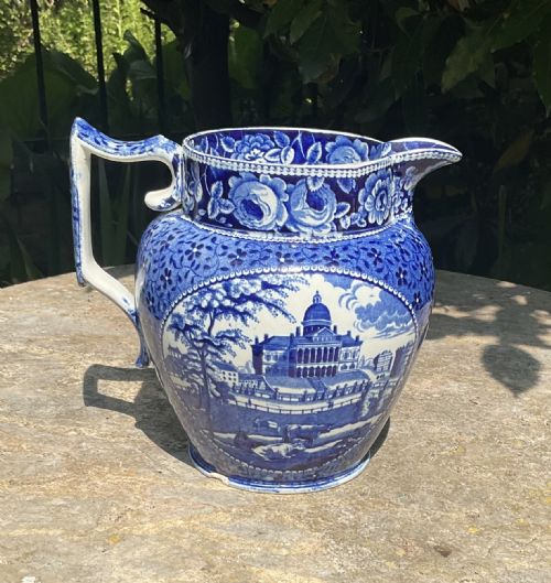 fig 1. A Georgian blue and white ceramic jug featuring an underglaze transfer print depicting an architectural building surrounded by a floral border.
