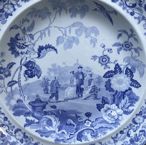 fig 1. A large Victorian blue and white stone china charger featuring a Chinoiserie landscape scene with figures and an intricate floral border.
