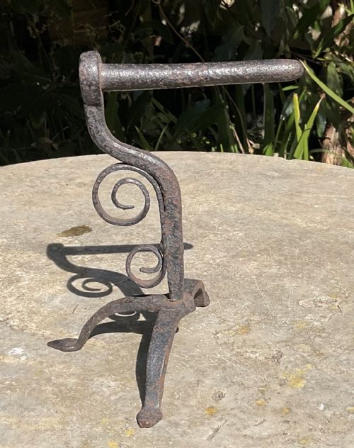 fig 1. An early 19th-century wrought iron goffering iron featuring a cylindrical barrel mounted on a scrollwork upright stem with a tripod base.