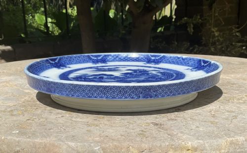fig 1. A circular Georgian blue and white ceramic bread stand featuring a detailed Chinoiserie buffalo pattern.