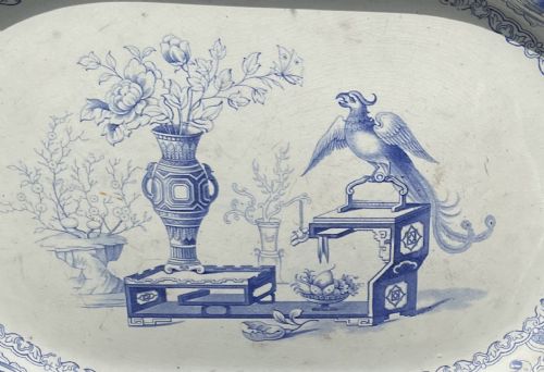 fig 1. An octagonal antique blue and white transfer-printed ceramic serving platter featuring a central bird motif and ornate floral borders.
