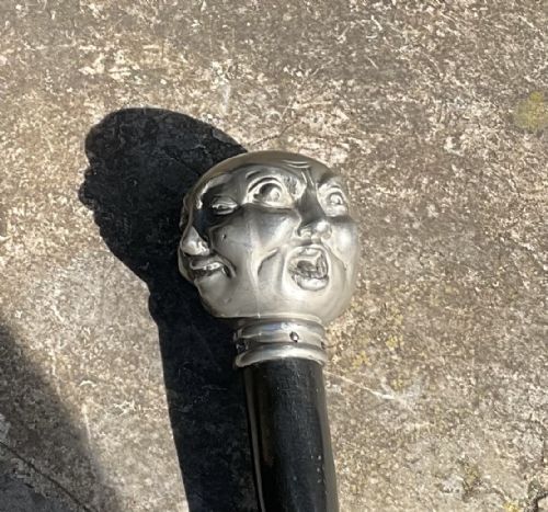fig 1. A Victorian page turner featuring a dark wooden blade attached to a pewter pommel carved with four distinct facial expressions.