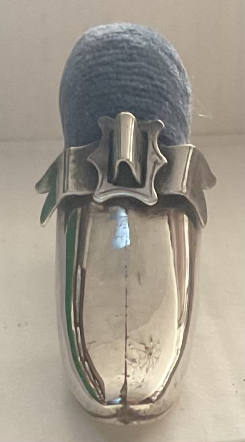 An Edwardian sterling silver pin cushion fashioned in the shape of a ladies high-heeled shoe with dark fabric upholstery. View II