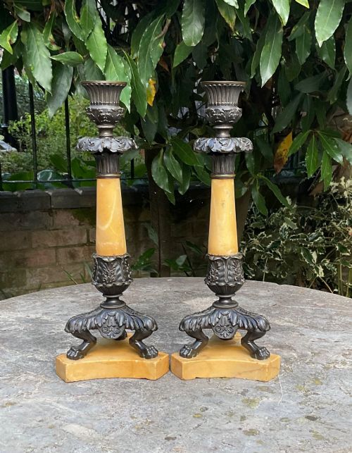 fig 1. A pair of Regency period candlesticks with yellow marble column stems, classical dark bronze sconces, acanthus collars, and bronze paw feet on triform marble bases.