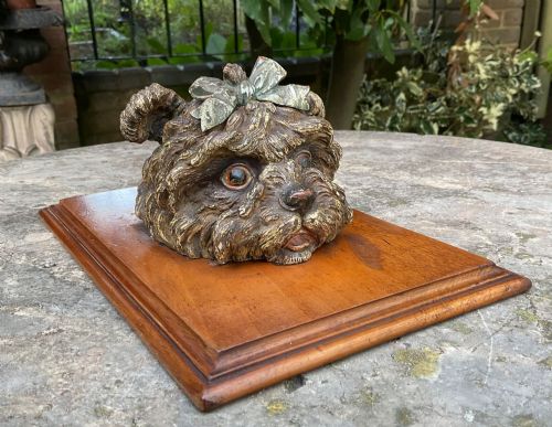 fig 1. An antique Austrian cold-painted bronze head of a Yorkshire Terrier with a green bow, mounted on a rectangular timber base as a spring paper clip.