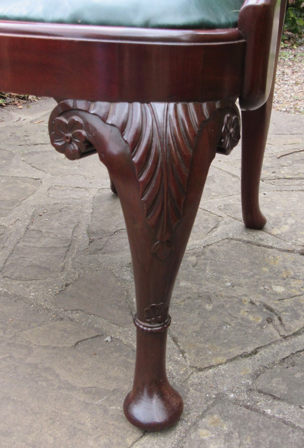 A Georgian style dark mahogany open armchair featuring a vase-shaped back splat, curved arms, a green leather seat, and carved cabriole front legs. View VIII