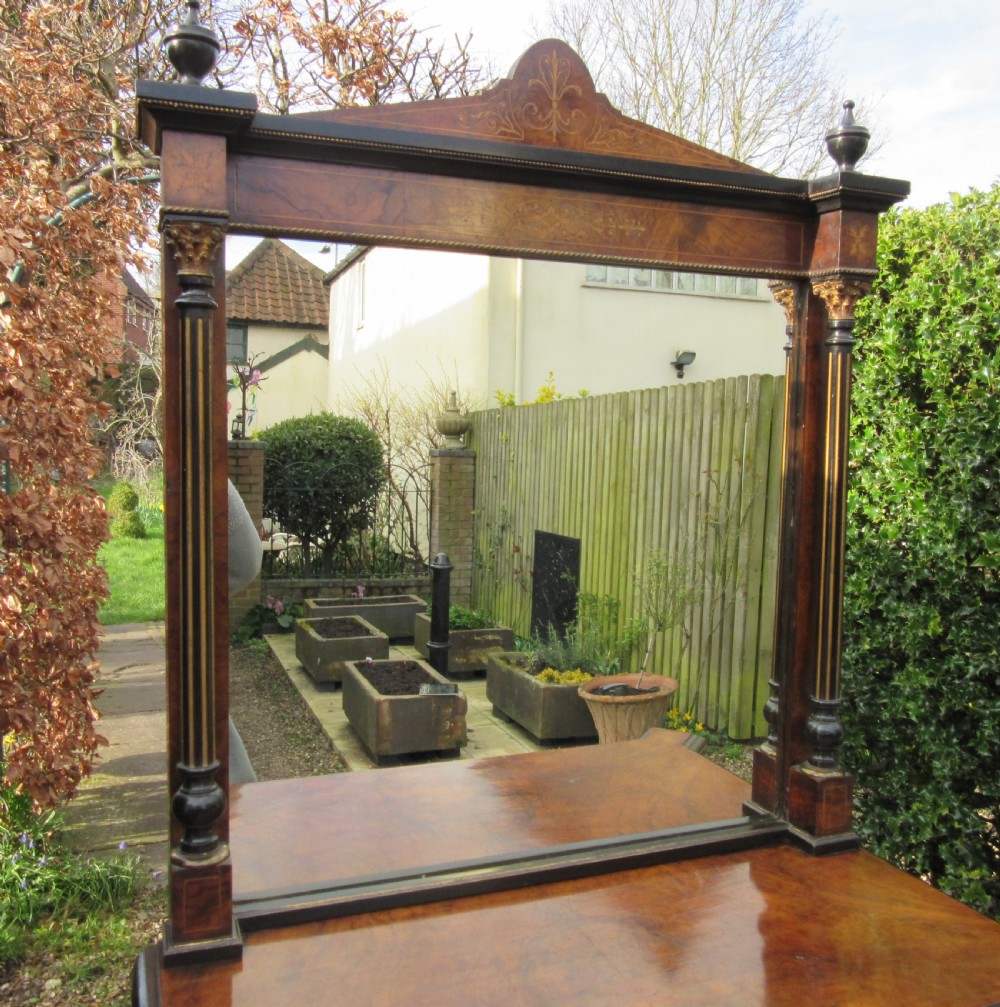 A Victorian walnut display cabinet with a single glazed door, side glass panels, floral marquetry, ebonised columns, and an upper mirror frame topped with finials. View V