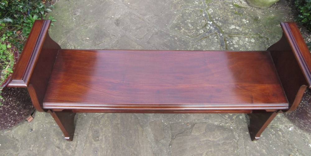 An Art Nouveau solid walnut hall bench featuring elevated end panels with pierced cut-outs and a low stretcher rail. View V